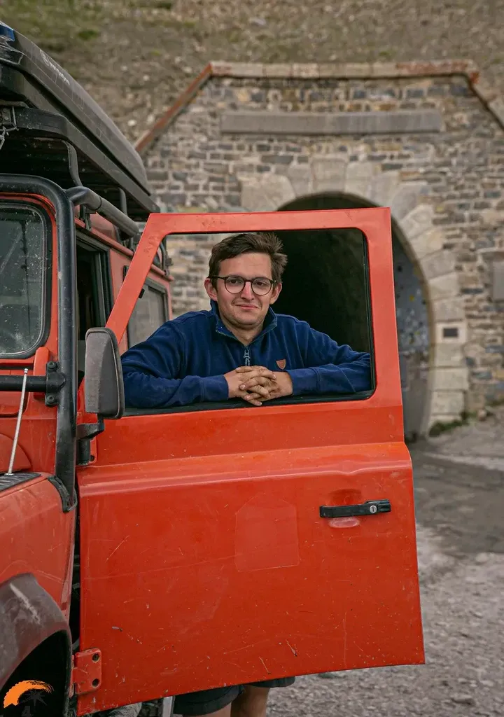 Photo d'Antoine à côté de sa voiture orange